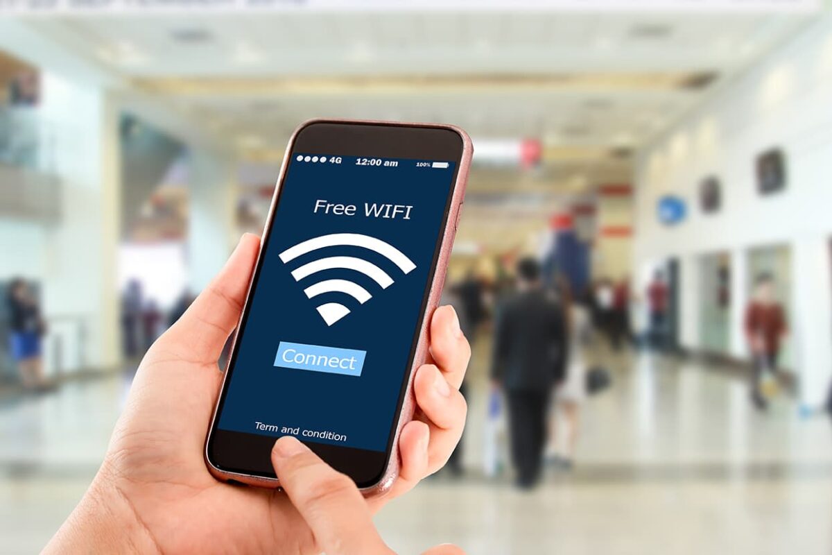 Hand holding a smartphone connecting to free wifi in public area