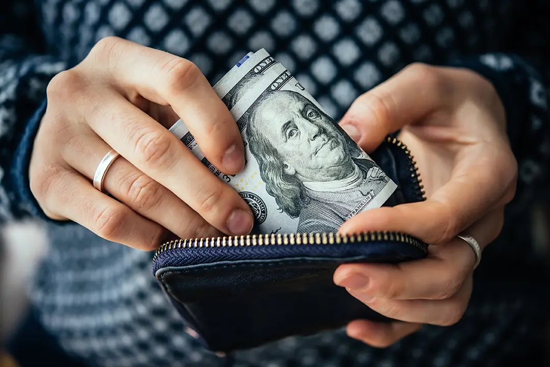 woman putting money in wallet