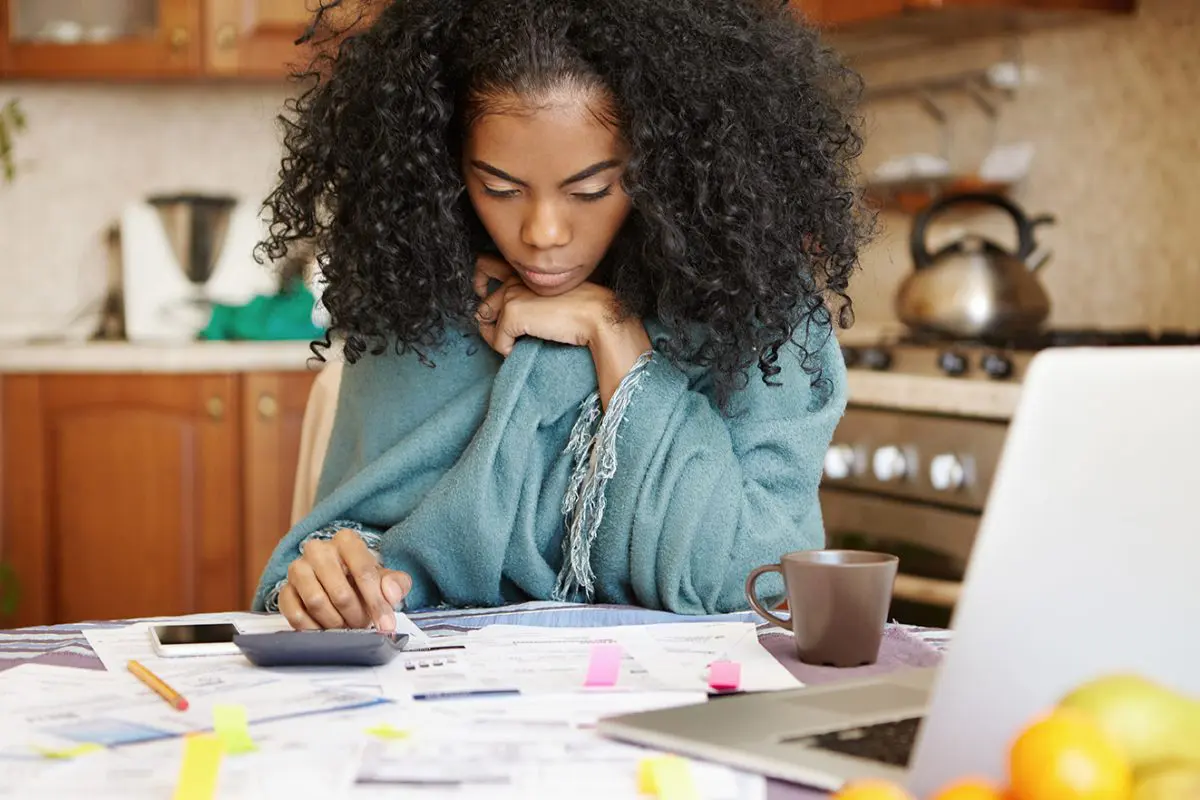 woman sitting at table working on finances