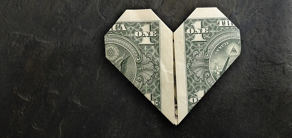 Origami money heart on textured slate background