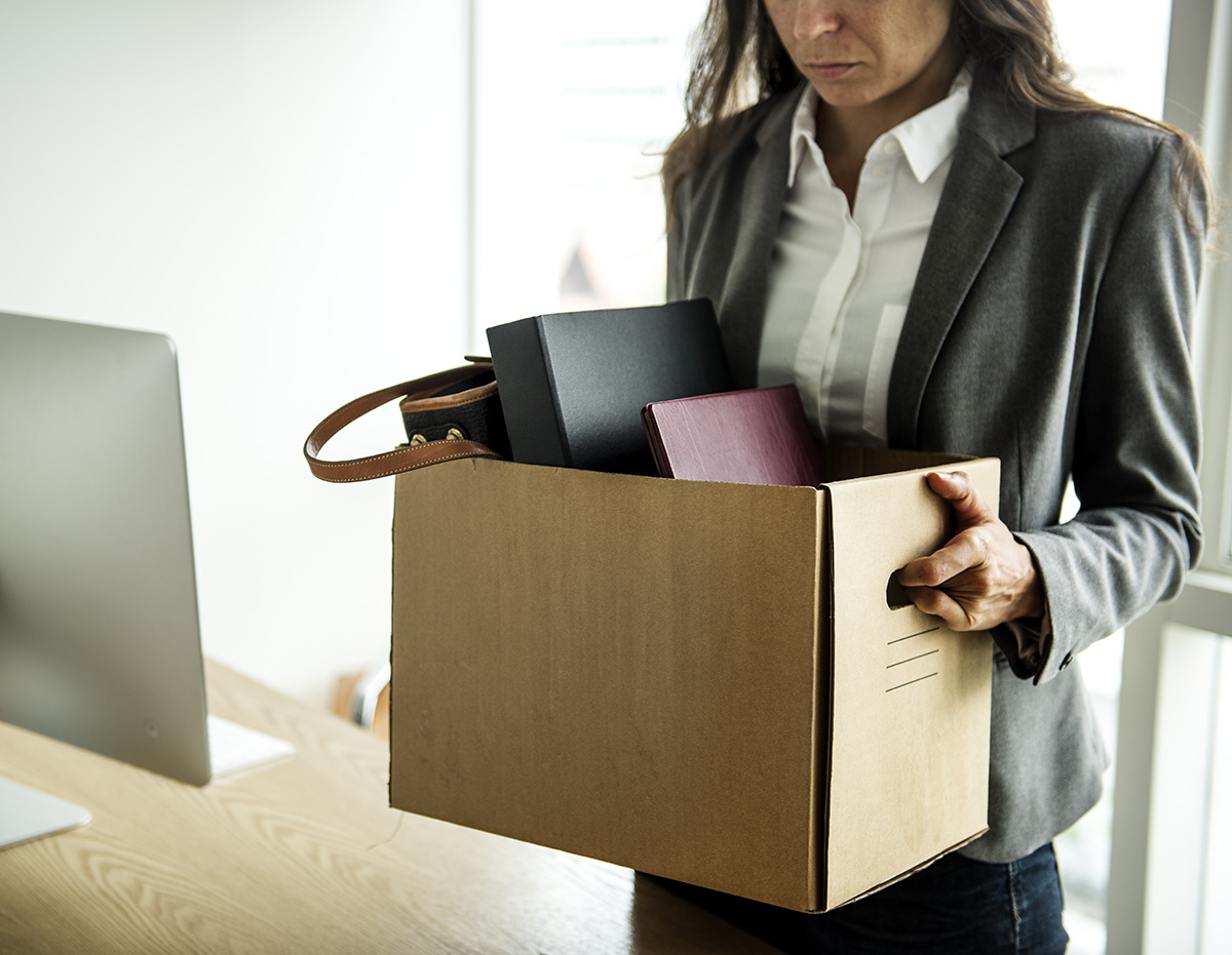 Sad woman office employee holding box with personal items