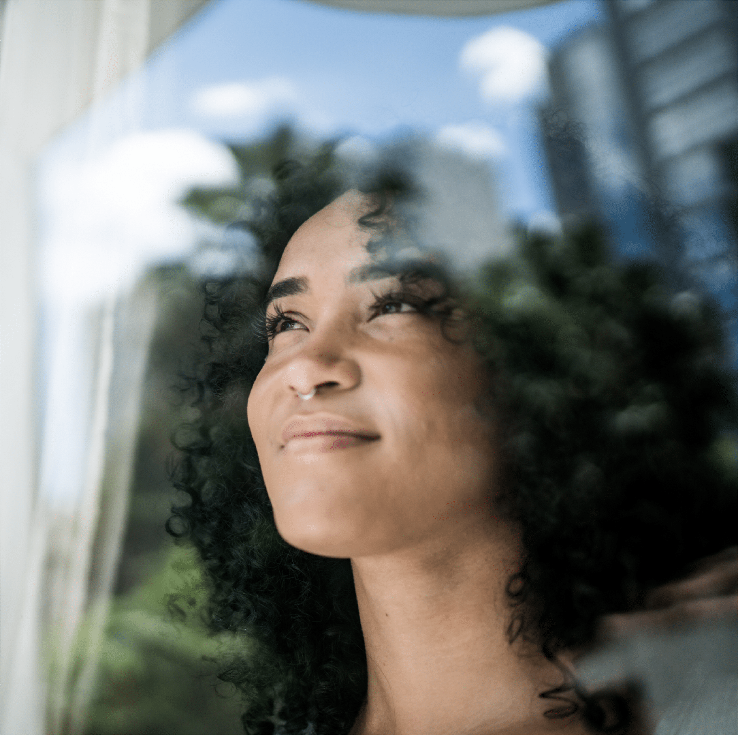African american woman gazing through window, happy